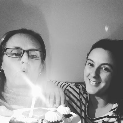 Mother daughter business owners with birthday cake and candles